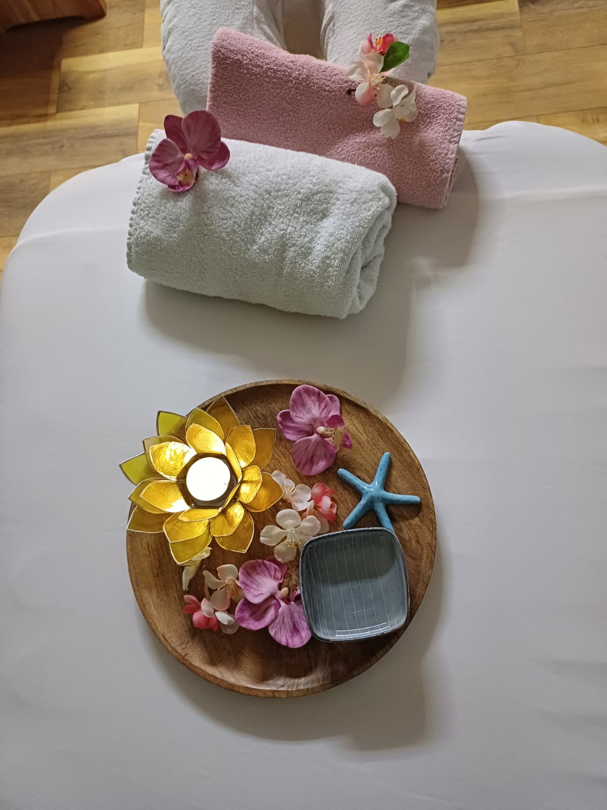 table-design otusblume auf Holz-Teller auf Massage-Tisch, Symbol der Ruhe für Craniosacral Therapie
